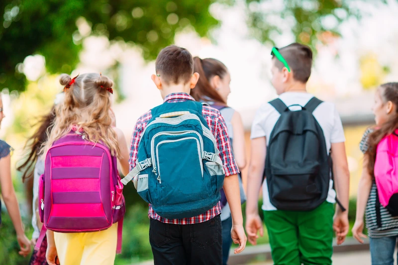 alunos com mochila nas costas indo embora