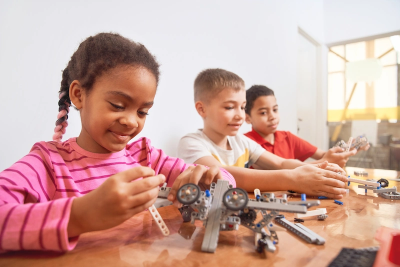 aluna com kit de robotica na sala de aula