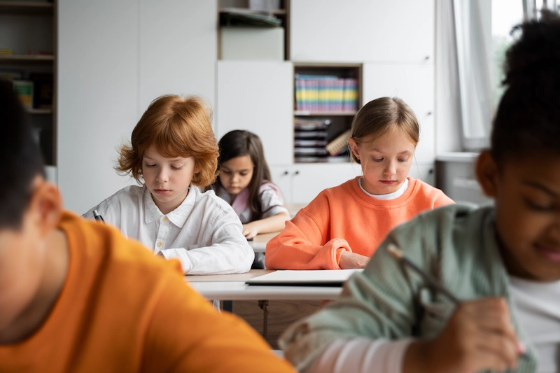 alunos em sala de aula focados escrevendo