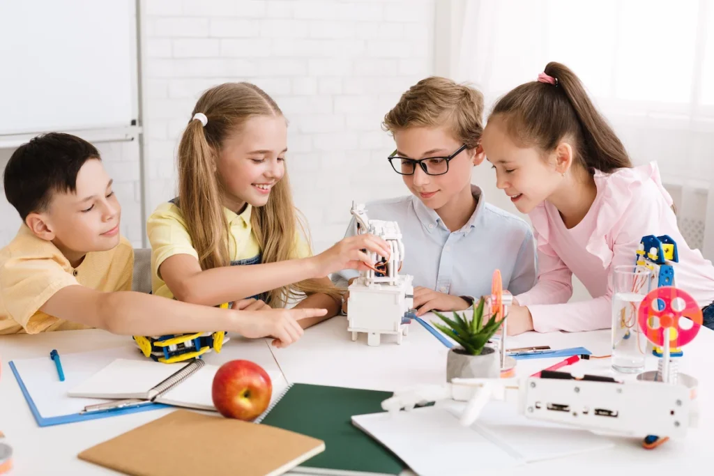 alunos pre adolescentes em volta da mesa realizando trabalho em grupo